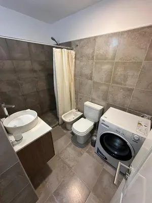 a bathroom with a toilet sink and a washing machine at Departamento en calle Obispo Trejo NVA CBA in Cordoba