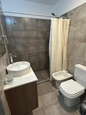 a bathroom with a toilet and a sink and a shower at Departamento en calle Obispo Trejo NVA CBA in Cordoba