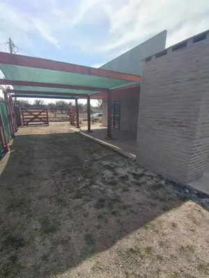 a building with awning next to a grass field at El paraiso in Villa del Dique