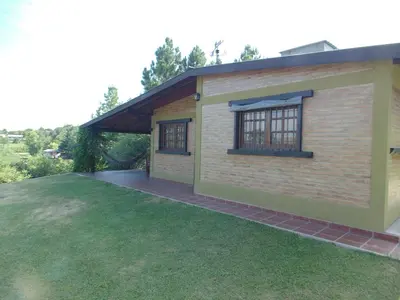 a small house with a patio and grass at Cabañas los amigos Chañar in Potrero de Garay