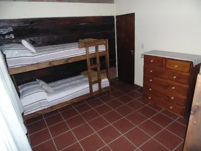 a room with a pile of mattresses and a dresser at Cabañas los amigos Chañar in Potrero de Garay