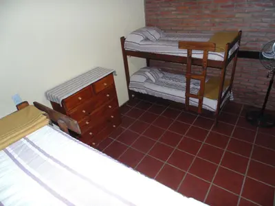 a bedroom with two bunk beds and a brick wall at Cabañas los amigos Chañar in Potrero de Garay
