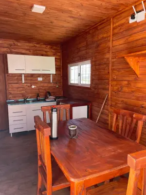 a kitchen and dining room with a wooden table at Kapo TEAM , la calandria in Villa Amancay