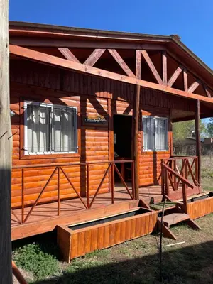 a large wooden cabin with a porch and windows at Kapo TEAM , la calandria in Villa Amancay