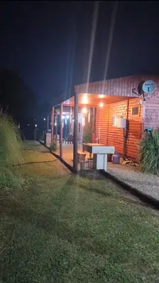 a house with a picnic table in front of it at night at Kapo TEAM , la calandria in Villa Amancay