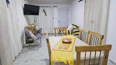 a living room with a table and chairs and a television at Cabaña La Luna in San Javier