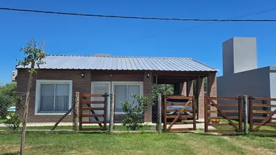 a small house with two wooden fences in front of it at Cabaña La Luna in San Javier