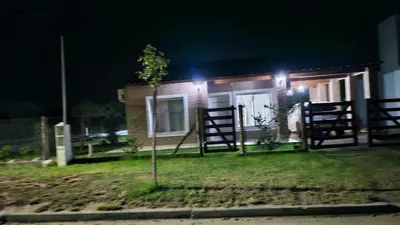 a small house with a tree in the yard at night at Cabaña La Luna in San Javier