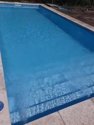 a blue swimming pool with water in it at Cabaña La Luna in San Javier