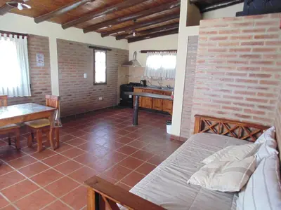 a bedroom with a bed and a table and a piano at Cabañas los amigos Tala in Potrero de Garay