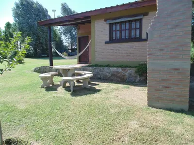 a picnic table in front of a house at Cabañas los amigos Tala in Potrero de Garay