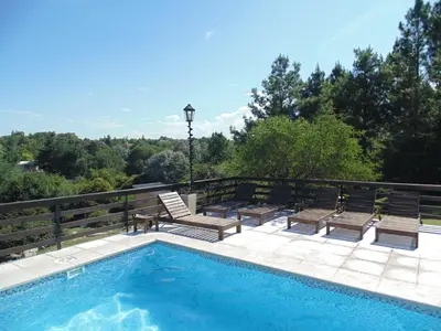 a swimming pool with two chairs and a light pole at Cabañas los amigos Tala in Potrero de Garay