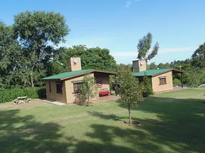 a small house with a tree in the yard at Cabañas los amigos Tala in Potrero de Garay