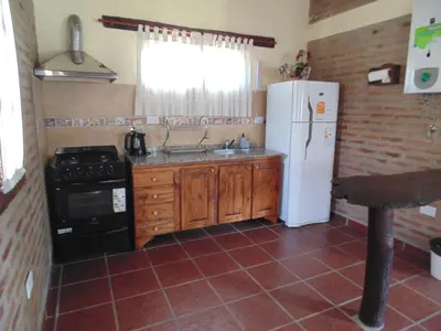 a kitchen with a white refrigerator and a sink at Cabañas los amigos Tala in Potrero de Garay
