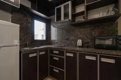 a kitchen with brown cabinets and a white refrigerator at Complejo Solares in Alta Gracia