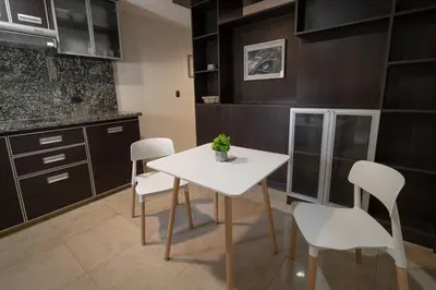 a kitchen with a white table and white chairs at Complejo Solares in Alta Gracia