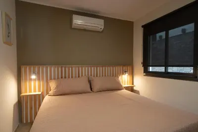 a bedroom with a bed with two lamps and a window at Complejo Solares in Alta Gracia