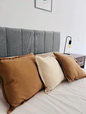 a pile of pillows sitting on top of a bed at Aguaribay duplex Nuevo Centro in Cordoba