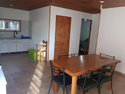 a dining room with a wooden table and chairs at Los 3 soles in Villa Ciudad Parque