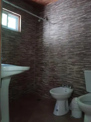 a bathroom with a sink and a toilet and a window at Los 3 soles in Villa Ciudad Parque
