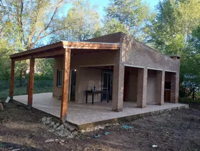 a small brick house with a wooden roof at Los 3 soles in Villa Ciudad Parque