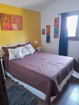 a bedroom with a large bed and a window at Cabañas Lauquen Villa Carlos Paz in Villa Carlos Paz
