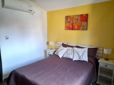a bedroom with a purple bed with two night stands at Cabañas Lauquen Villa Carlos Paz in Villa Carlos Paz