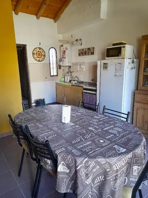 a kitchen with a table and a refrigerator at Cabañas Lauquen Villa Carlos Paz in Villa Carlos Paz
