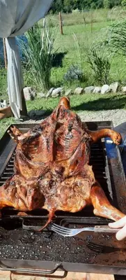a large piece of meat cooking on a grill at Cabaña Emmanuel in Santa Rosa de Calamuchita