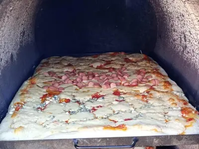 a pizza is being cooked in an oven at Cabaña Emmanuel in Santa Rosa de Calamuchita