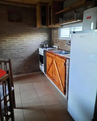 a kitchen with a refrigerator and a stove top oven at Cabaña Emmanuel in Santa Rosa de Calamuchita