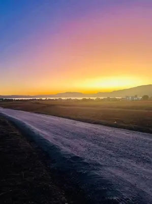 a dirt road with the sunset in the background at Casa Puerto del Águila in La Estancia