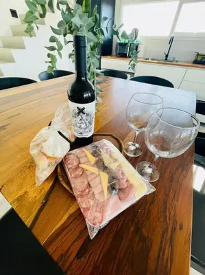 a bottle of wine sitting on top of a wooden table at Casa Puerto del Águila in La Estancia