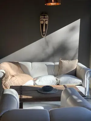 a living room with a white couch and a table at Cabaña del Bosque in Las Calles