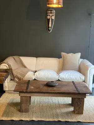 a living room with a white couch and a wooden coffee table at Cabaña del Bosque in Las Calles