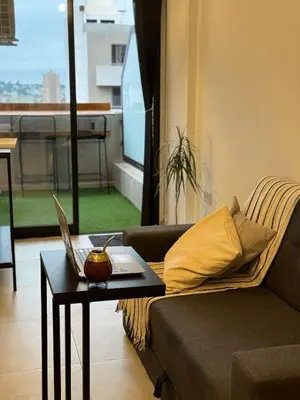 a living room with a couch and a table with a laptop at Depto a 3 cuadras de Patio Olmos in Cordoba