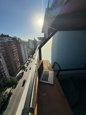 a laptop sitting on a table on the balcony of a building at Depto a 3 cuadras de Patio Olmos in Cordoba