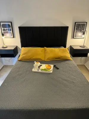 a bed with a tray of food on it at Depto a 3 cuadras de Patio Olmos in Cordoba
