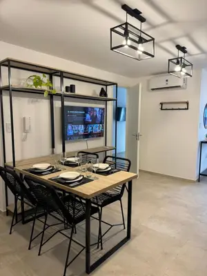a dining room with a table and chairs and a television at A 3 cuadras de Patio Olmos in Cordoba