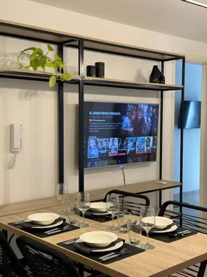a dining room table with chairs and a television at A 3 cuadras de Patio Olmos in Cordoba