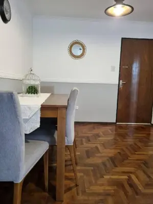 a dining room table with two chairs and a cabinet at Hermoso y cómodo Dpto en el centro in Cordoba