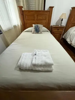 a white towel is laying on a bed at Hermoso y cómodo Dpto en el centro in Cordoba