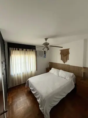 a bedroom with a white bed and a ceiling fan at Hermoso y cómodo Dpto en el centro in Cordoba