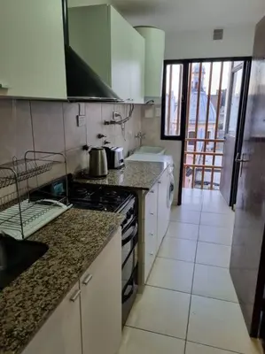 a kitchen with a stove and a counter top at Hermoso y cómodo Dpto en el centro in Cordoba