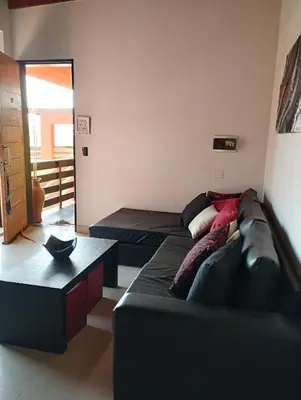 a living room with a couch and a table at Paraíso Serrano 12 in Villa Ciudad Parque