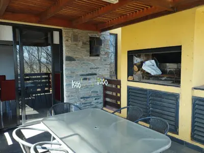 a patio with a table and chairs and a kitchen at Paraíso Serrano 12 in Villa Ciudad Parque
