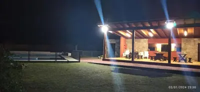 a house with a pool at night with lights at Paraíso Serrano 12 in Villa Ciudad Parque