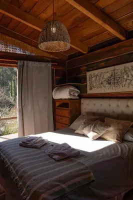 a bedroom with a bed in a wooden room at Willert Cabañas Cumbrecita in La Cumbrecita