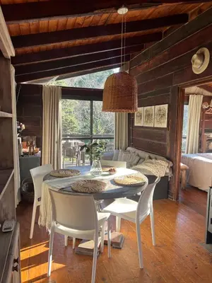 a dining room with a table and white chairs at Willert Cabañas Cumbrecita in La Cumbrecita