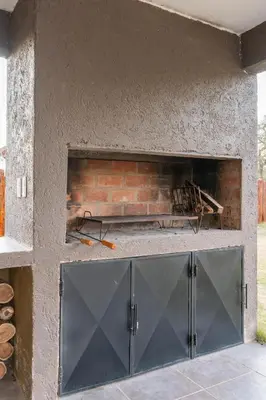 a brick fireplace behind a metal garage door at Cabañas Miraluna in Villa General Belgrano